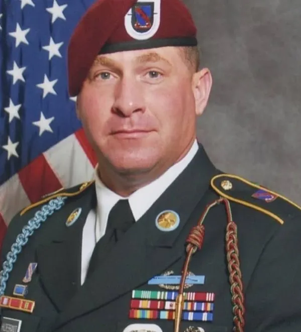 A man in military uniform and an american flag.